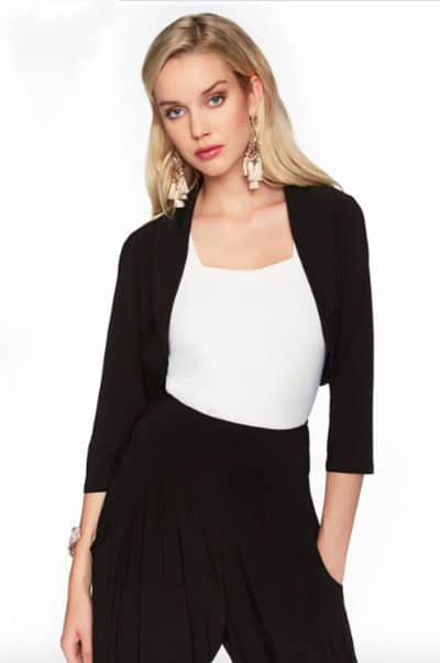 Stylish blonde woman wearing a black blazer and black wide-leg pants with a white top, posing confidently for a fashion photoshoot, showcasing modern business casual attire.