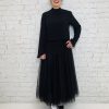 Elegant woman in black turtleneck and tulle skirt showcasing stylish fashion and modern outfit ideas, perfect for fall or winter wardrobe styling.