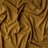 Luxurious gold silk fabric with elegant drapes showcasing high-quality craftsmanship, perfect for fashion, decor, or upholstery projects.