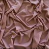 Soft blush pink velvet fabric with elegant draping and luxurious texture, ideal for fashion, home decor, or sewing projects. Perfect for creating sophisticated garments or stylish interior accents.