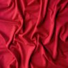 Luxurious red silk fabric with soft folds and elegant draping, perfect for high-end fashion and interior décor projects. Vibrant color and smooth texture enhance visual appeal and design versatility.