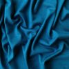 Luxurious teal silk fabric with soft draping and elegant texture, perfect for fashion, sewing, or home decor projects. Beautiful, high-quality textile ideal for creating stylish garments or accessories.