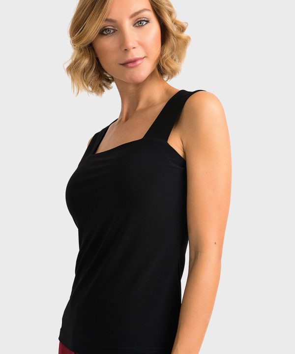 Elegant woman in black sleeveless top and maroon pants on white background, showcasing stylish and comfortable fashion look, perfect for casual or professional settings, by Katyamaker.