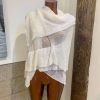 Soft beige knit shawl draped over mannequin torso, perfect for layering and cozy winter styling.