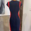 Vibrant navy dress with red side panels, tailored for a modern, flattering fit, displayed on a mannequin in an artisanal fashion studio.