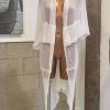 Light, sheer white caftan with flowing fabric, perfect for beachwear or summer resort fashion, displayed on a mannequin.