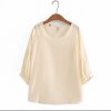 Soft ivory satin blouse with 3/4 sleeves and keyhole tie closure, perfect for elegant casual wear or special occasions.