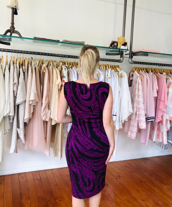 Elegant woman shopping for feminine dresses in a boutique, showcasing stylish pink, white, and beige clothing, perfect for fashion enthusiasts interested in trendy women’s apparel.