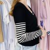 Soft black cardigan with striped sleeves, stylish women's fashion, layered outfit for fall, casual chic clothing, modern streetwear style.