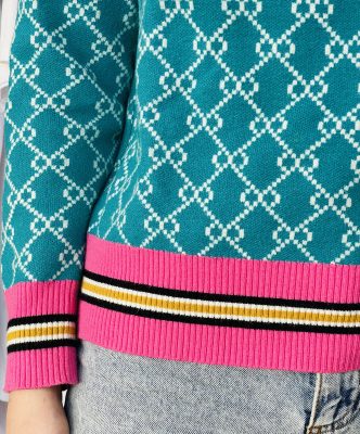 Bright blue patterned knit sweater with white geometric design and colorful striped hem, casual fashion styling.