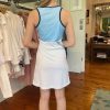 Sporty blue and white athletic tank top with contrast trim, paired with a white skirt, inside boutique clothing store, lifestyle, fashion, casual wear, women's activewear, katyamaker.