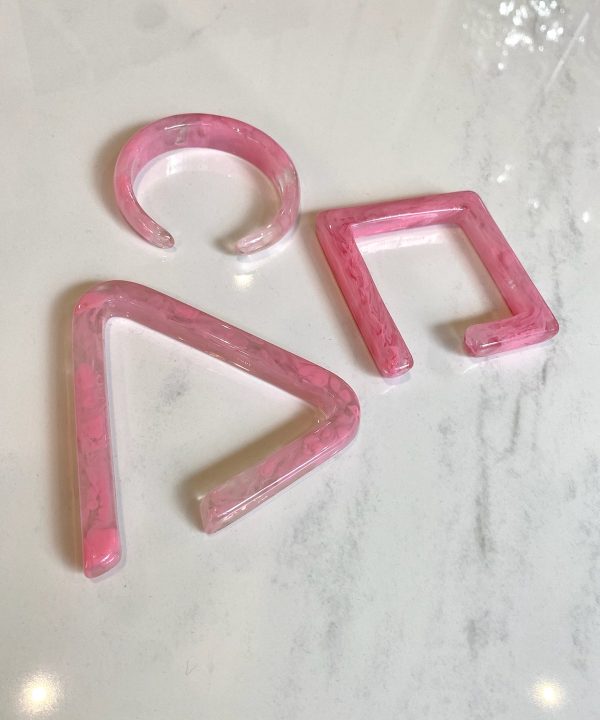 Pink marbled acrylic letter shapes spelling "PR" on a white marble surface. Modern, trendy decorative letters for home decor, embellishments, or personalized crafts. Perfect for stylish interior accents.