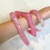 Pink resin statement jewelry set on an arm, including thick bangles and a bold cuff, perfect for modern accessories and fashion statement pieces.