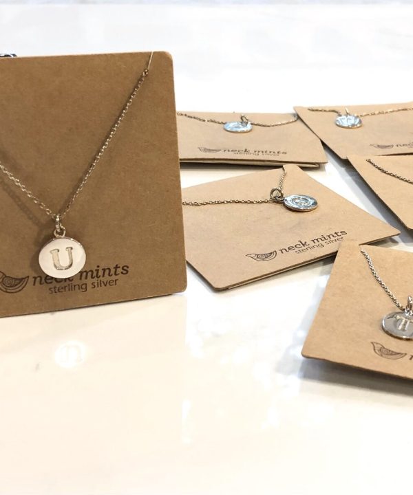 U sterling silver initial pendant necklace on a delicate chain, featured among similar jewelry pieces on kraft display cards from neck_mints, showcasing handmade personalized sterling silver jewelry.