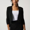 Elegant woman in black blazer and white top, professional fashion portrait.