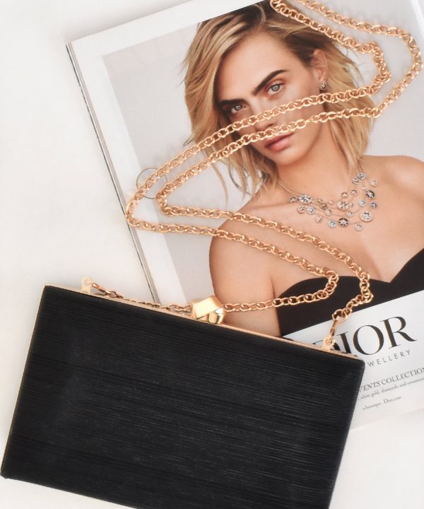 Rose gold chain necklace with jewelry box and fashion magazine featuring a woman with blonde hair and elegant jewelry, showcasing stylish accessories and jewelry collection.