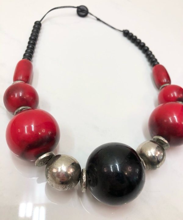 Colorful statement necklace with large red, black, and metallic beads, handcrafted jewelry design, bold accessories for women, perfect for casual or special occasions.