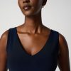 Elegant portrait of a modern African woman with short hair, wearing a navy blue sleeveless dress, showcasing minimalist style and confident attitude for fashion and beauty SEO.