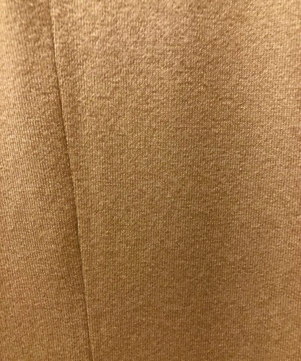 Soft beige knitted fabric texture in close-up.