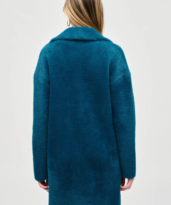 Luxurious teal faux fur coat featuring a classic collar, designed for chic winter style, perfect for fashion-forward individuals seeking warmth and elegance.