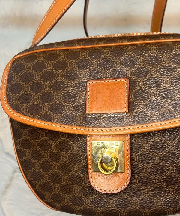 Luxury designer handbag, Celine Paris monogram pattern, brown and tan leather accents, gold hardware, stylish and high-end fashion accessories, women's handbag for elegant occasions.