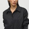Black button-up shirt with white polka dots, women's fashion, elegant casual wear, stylish office attire, modern sophisticated look.