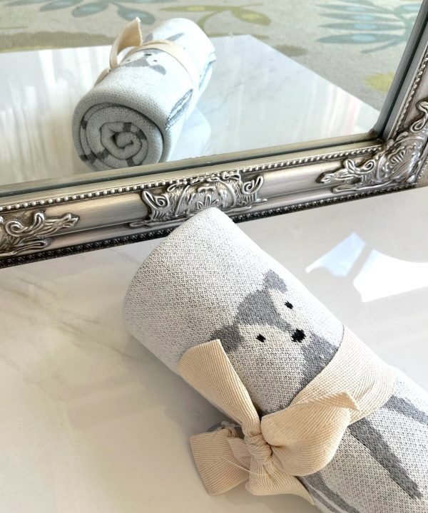 Soft gray and cream sock with adorable animal design, featuring a cute puppy illustration, tied with a beige bow, perfect for cozy home decor or gift-giving, displayed near a decorative mirror.