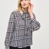 Elegant houndstooth blouse with tie-neck detail, perfect for fall fashion and stylish office wear.