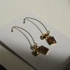 Gold dangle earrings with square amber gemstones and heart charms, elegant jewelry for women, handmade designer earrings, stylish party accessories, katyamaker fashion jewelry.