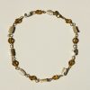 Delicate beaded necklace featuring gold, cream, and black faceted beads with gold chain accents, perfect for boho-chic or elegant jewelry styles.