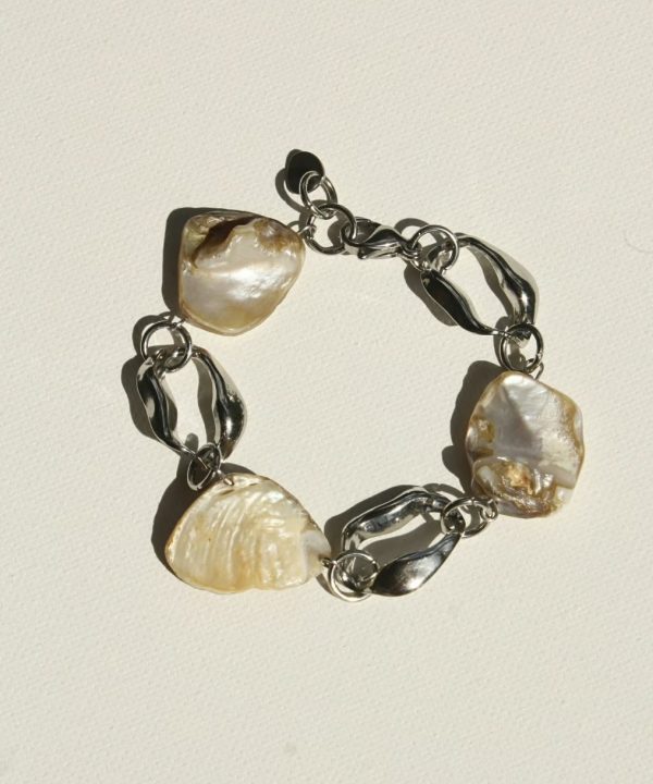 Pearl shell jewelry bracelet with large, irregularly shaped white pearls and chunky silver chain links on a white background.