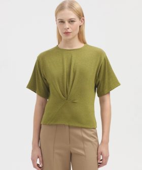 Soft green short-sleeve knit top styled with beige trousers, minimalist fashion, casual chic, spring/summer look, simple elegance, comfortable women's clothing, modern wardrobe essential.
