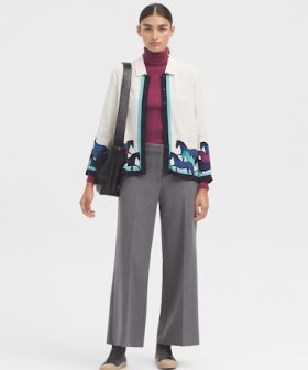 Elegant women's fashion featuring a stylish jacket with colorful horse embroidery, paired with tailored gray wide-leg pants and a chic turtleneck, perfect for modern professional or casual wear.