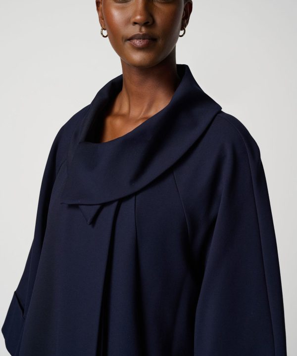 Elegant dark navy cape coat with draped collar, women’s stylish fall and winter fashion by Katya Maker. Perfect for sophisticated, modern wardrobe essentials.