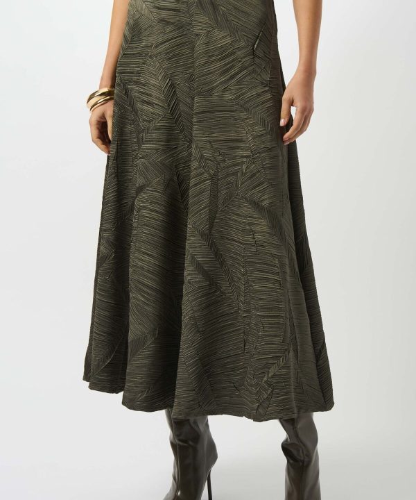 Elegant botanical-print maxi skirt in olive green, styled with knee-high dark leather boots for a chic, sophisticated look. Perfect for fashion-forward outfits and outdoor events.