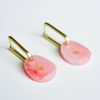 Delicate pink resin earrings with gold star accents, featuring gold clip-on findings, stylish and unique jewelry pieces perfect for accessorizing any outfit.
