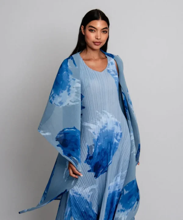 Flowy blue and white abstract-patterned dress and matching cape, modern fashion look from Katya Maker collection emphasizing artistic prints and elegant design.