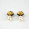 Elegant pearl and gold clip-on earrings featuring black accents, perfect for sophisticated jewelry styling and special occasions.