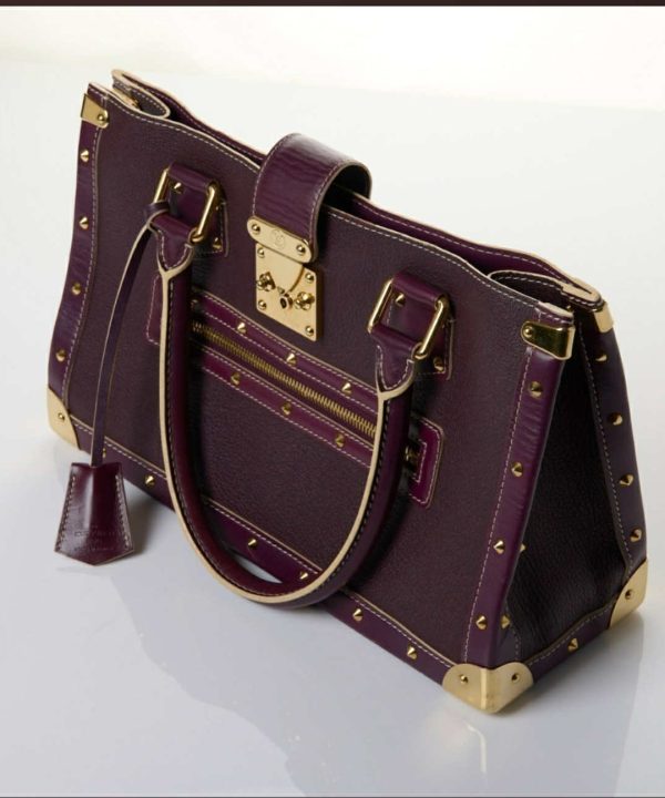 Luxury purple leather handbag with gold accents and studs, stylish designer bag for women, high-end fashion accessory, handcrafted leather purse, designer tote for everyday use.