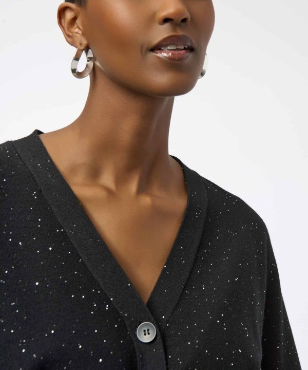 Elegant woman wearing a black speckled cardigan, showcasing stylish jewelry and modern fashion accessories, perfect for fashion-forward looks and everyday wear.
