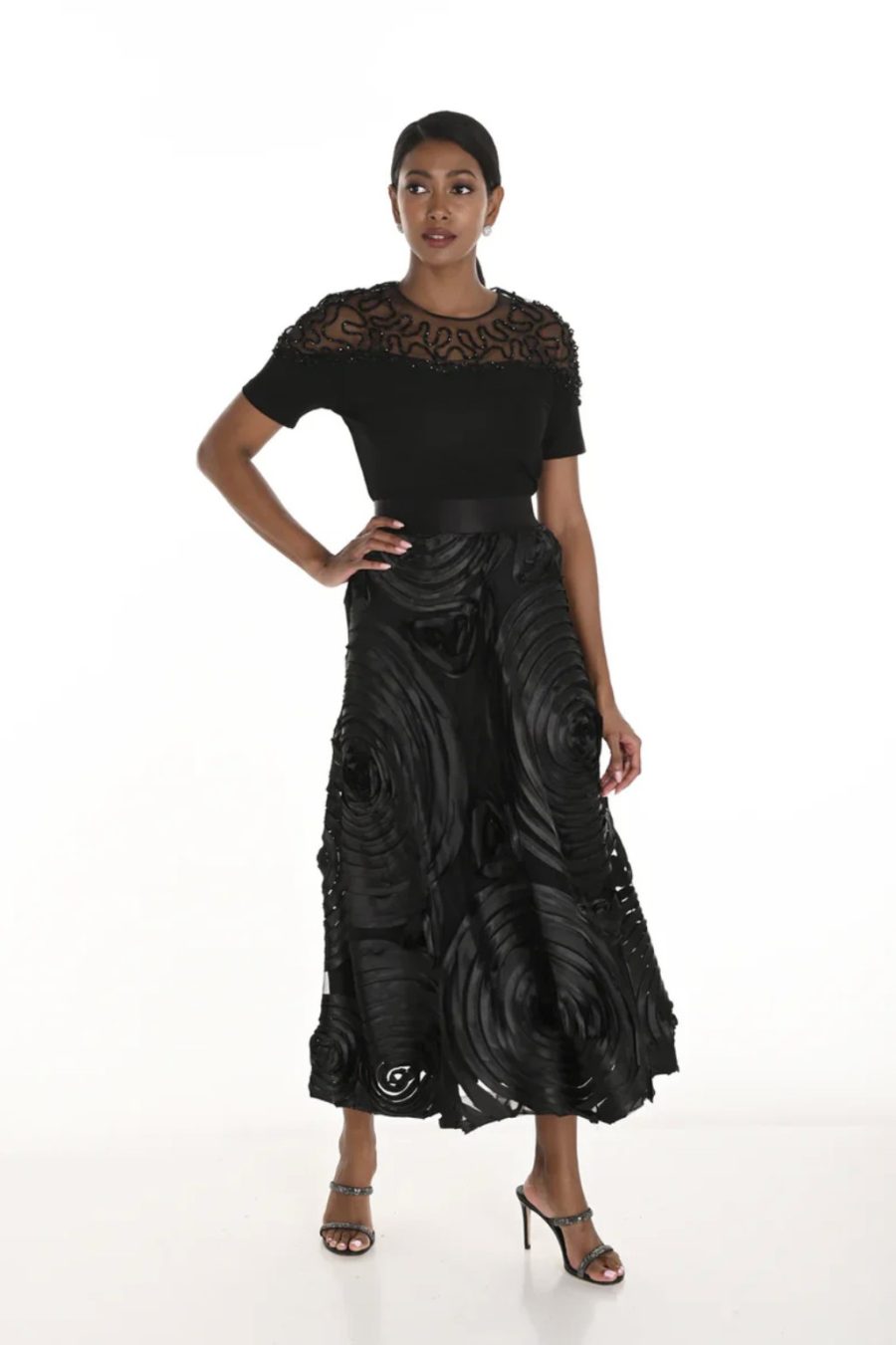 Elegant black designer outfit featuring intricate lace detailing and statement fabric textures for women’s fashion and evening wear.