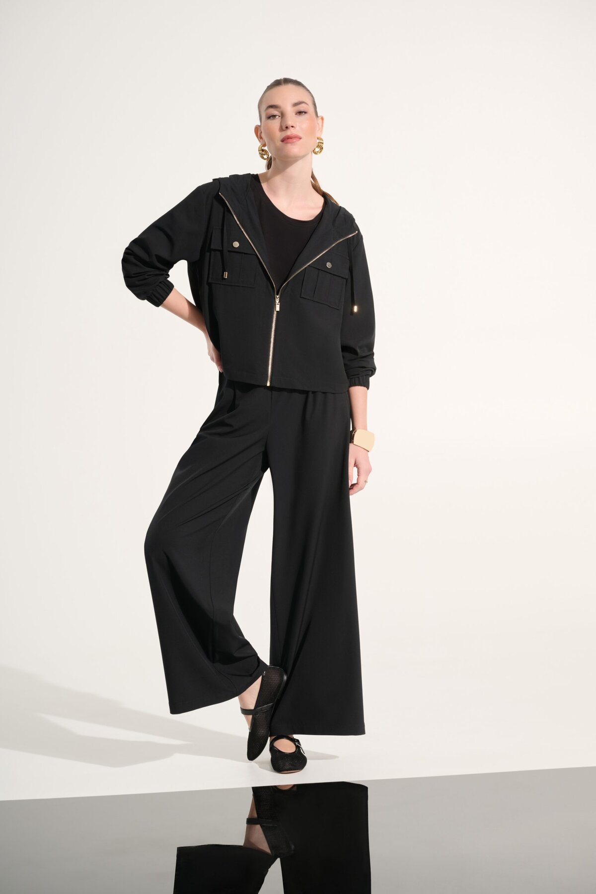 Elegant black athleisure outfit featuring a stylish zip-up jacket, wide-leg pants, and trendy accessories, perfect for casual-chic looks.