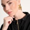 Elegant woman wearing statement gold earrings and a black hoodie, showcasing contemporary jewelry design and fashion accessories. Perfect for stylish, modern jewelry enthusiasts.