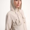 1. Women’s beige hooded jacket with front pockets, gold zipper, and adjustable drawstrings, perfect for casual and activewear.