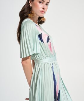 Elegant woman modeling a stylish floral pleated dress with ruffled sleeves, perfect for spring and summer fashion.